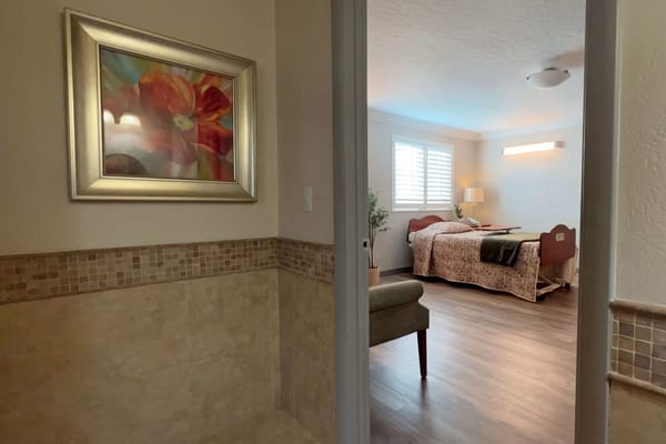 View of a cozy bedroom with a floral painting and a bed