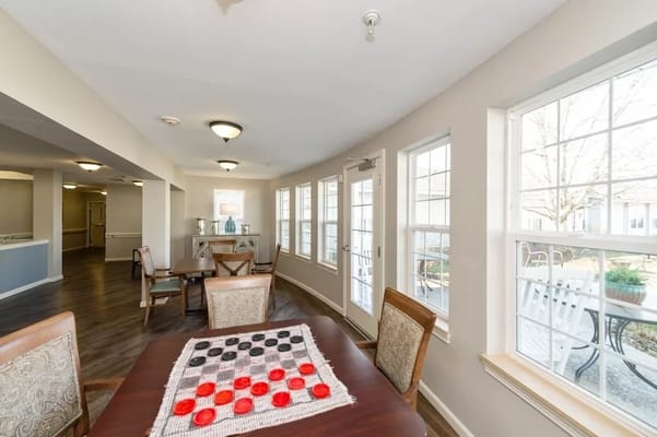 Bright common area with a game table and windows
