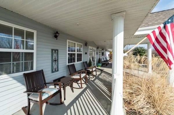 Outdoor seating area with rocking chairs and an American flag