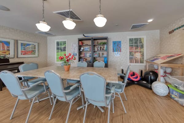 Bright common area with a large table and bookshelves
