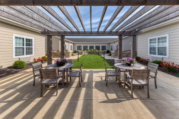 Outdoor seating area with tables and chairs in a garden