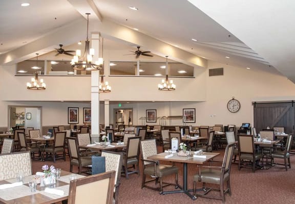 Dining room with tables and chairs set up for residents