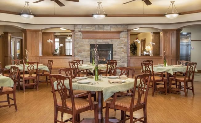 Bright dining room with wooden tables and a fireplace