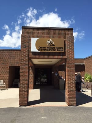 Entrance view of Central Montana Nursing and Rehabilitation Center with brick facade and sign.