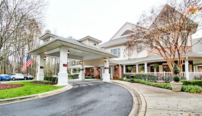 Main entrance of Charter Senior Living facility with a circular driveway and American flag.