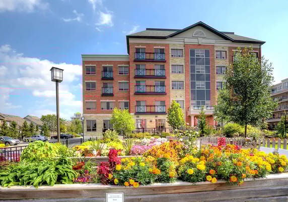Exterior view of Chartwell Carlton Retirement Residence with flower gardens