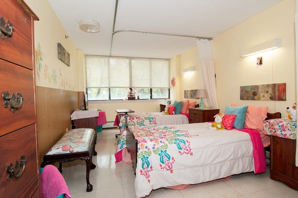 Shared bedroom with colorful bedding and furniture