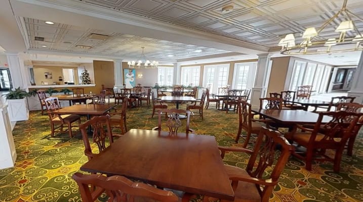Spacious dining area with wooden tables and chairs at Cherry Blossom Senior Living.