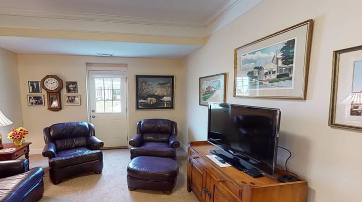 Lounge area with leather chairs, TV, and decorative wall art