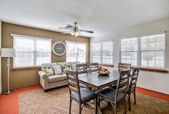 Bright dining area with a table and chairs beside windows