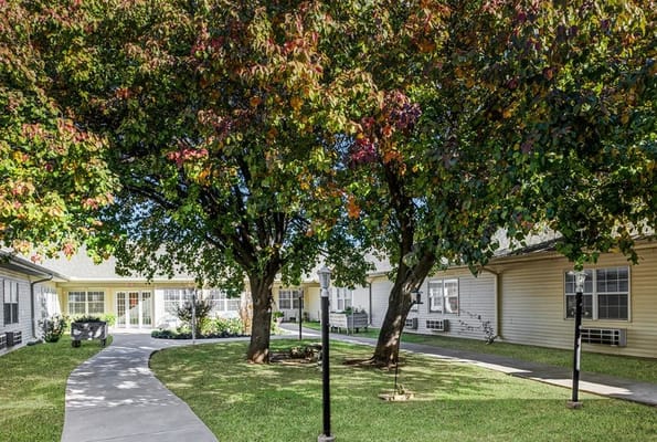 A landscaped pathway surrounded by trees at Chisholm Court senior living facility.