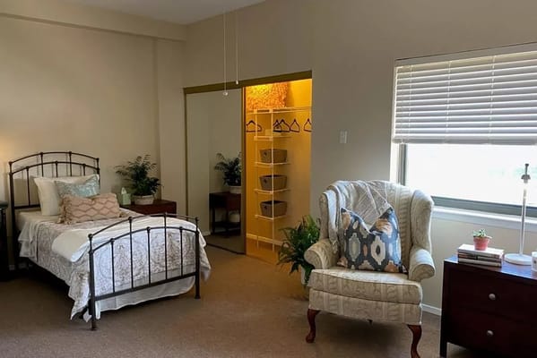 Cozy interior of a private resident room with bed and chair