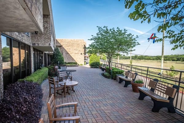 Outdoor seating area with pavers and greenery