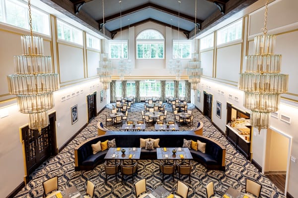 Bright dining room with elegant chandeliers and seating