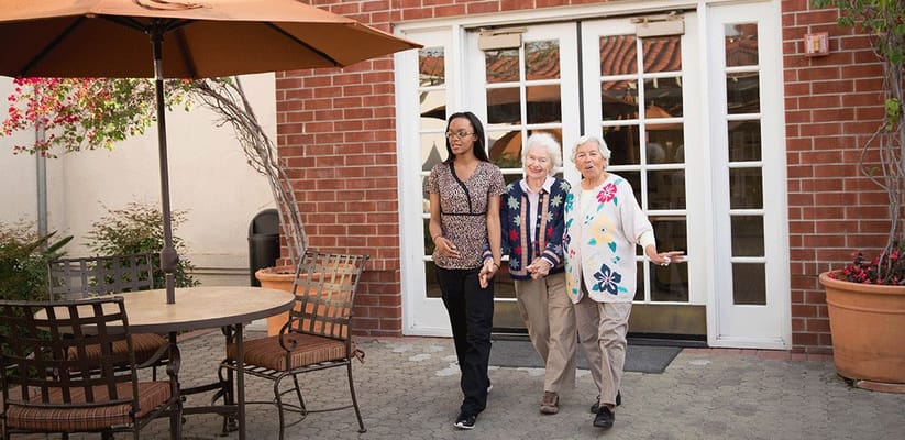 Residents enjoying a walk in the outdoor garden area