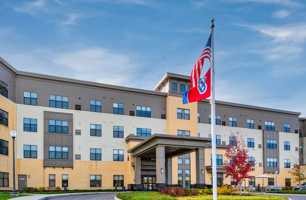 Exterior view of Clarendale at Bellevue Place with flags