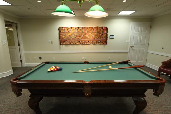 Pool table in a common room with decorative wall art
