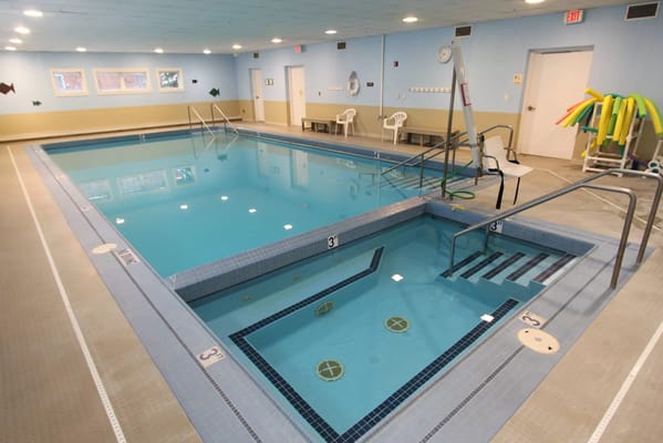 Indoor pool area with seating and safety equipment