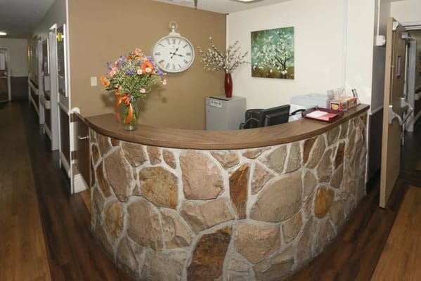 Reception area with a stone counter and flowers