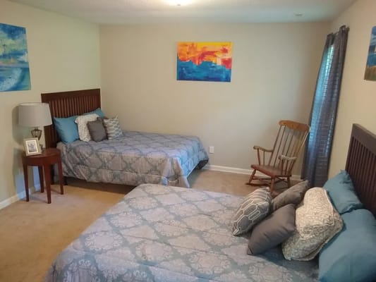 A cozy resident room with two beds and decor