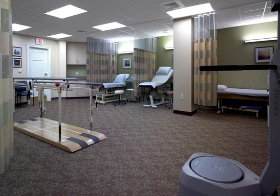 Well-equipped therapy room with treatment tables and exercise apparatus