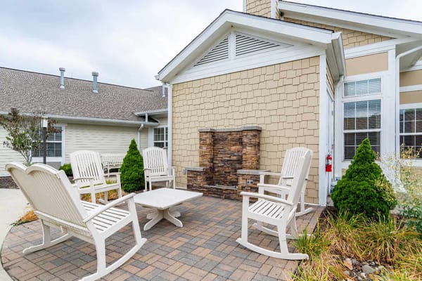 Outdoor seating area with chairs and a stone feature