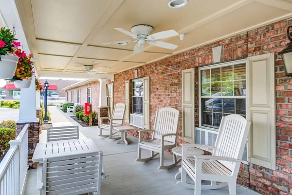 Outdoor seating area with rocking chairs and flowers