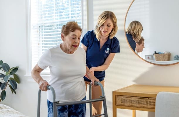Caregiver assisting a resident with a walker