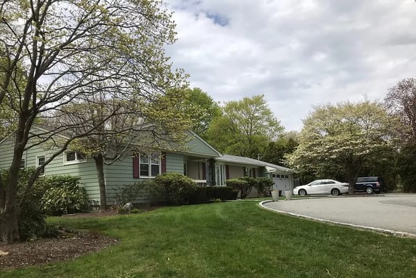 Exterior view of a senior living facility with green landscape