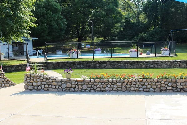 Outdoor pool area with landscaped flower beds