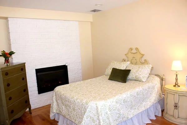 Cozy private resident room with a bed and fireplace