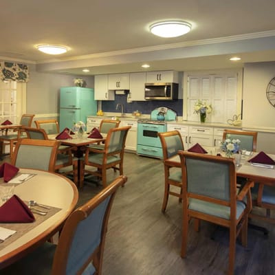Bright and inviting dining area with teal accents and tables set for a meal