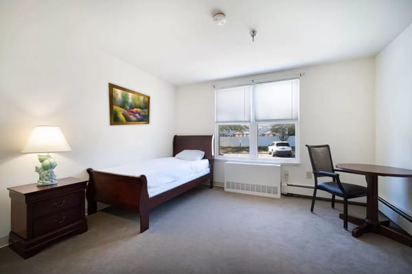 Brightly lit resident room with a bed and furniture