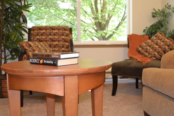 A wooden table with books in a cozy living room setting.