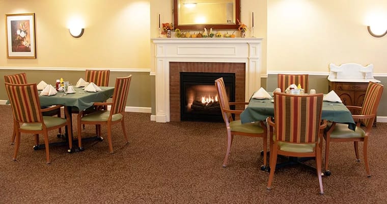 Dining room with tables set for a meal and fireplace