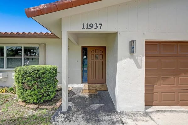 Exterior view of facility entrance with door and landscaping