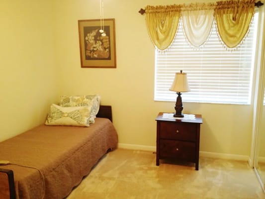 A cozy bedroom with a bed, nightstand, and window