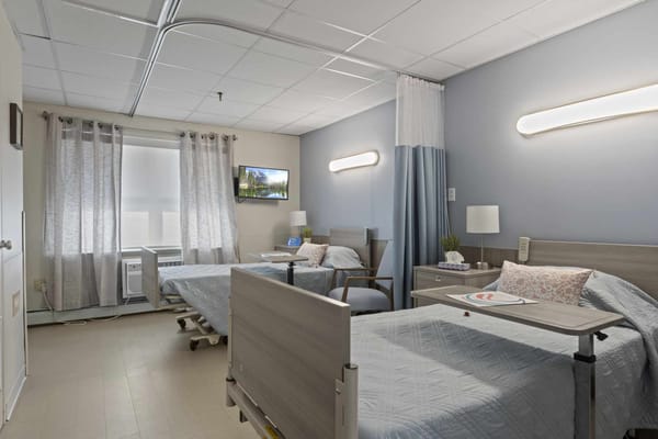 A shared resident room with two beds and amenities