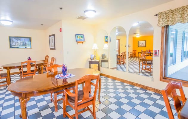 Bright dining room with wooden tables and chairs at Cottonwood Manor