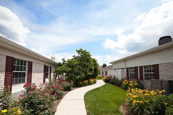 Pathway surrounded by flowers leading to facility buildings