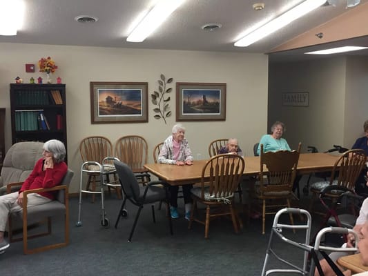 Residents sitting in a common area with a long table