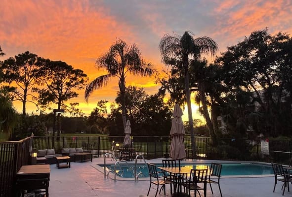 Outdoor pool area with sunset sky