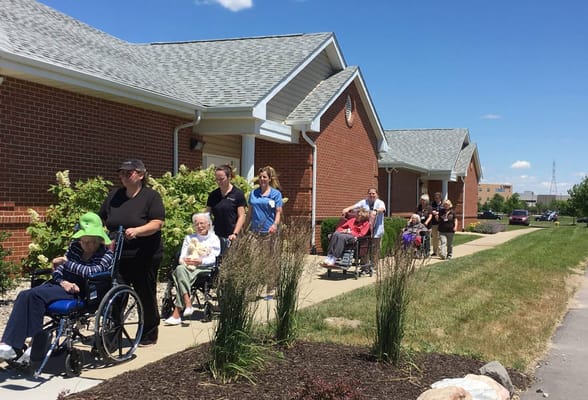 Residents and staff walking along a pathway outside Creasy Springs Health Campus.