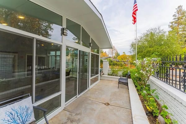 Outdoor patio area with seating and greenery.