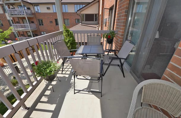 Balcony with seating and plants at a senior apartment