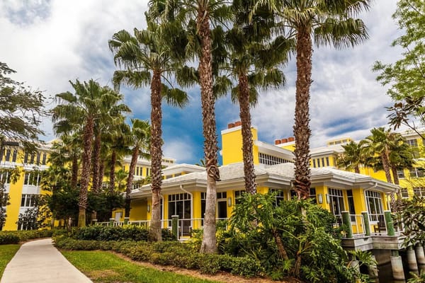 Exterior view of a vibrant assisted living facility surrounded by palm trees