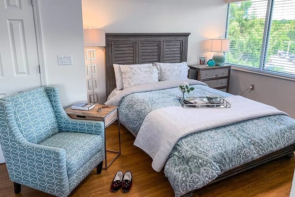 A cozy resident room with a bed and seating area