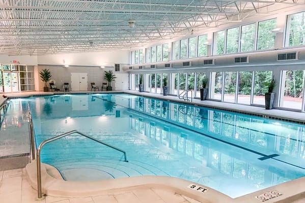 Indoor pool area with large windows and seating