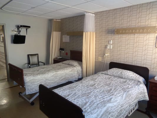 A shared resident room with two beds and basic amenities