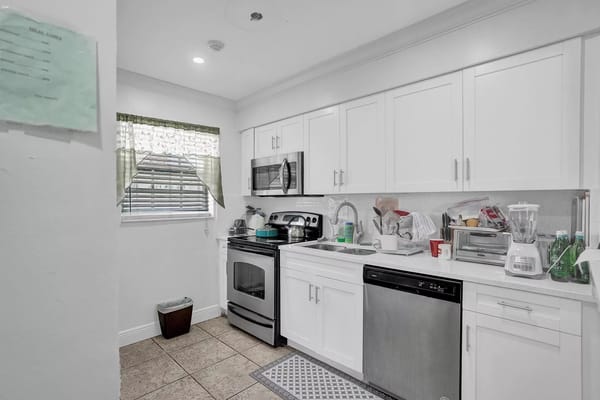 Bright kitchen area with modern appliances and some clutter
